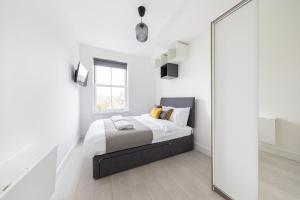 a white bedroom with a bed and a mirror at London Double Bedroom Hotel In Tufnell Park With WiFi in London