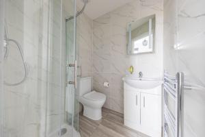 a bathroom with a toilet and a sink and a shower at London Double Bedroom Hotel In Tufnell Park With WiFi in London