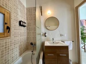 a bathroom with a sink and a tub and a mirror at Casa “Can Boira” in Valldemossa