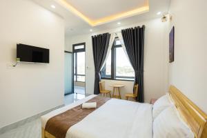 Hải Âu Villa Hotel في Ấp Kim Thạch: غرفة فندق بسرير وتلفزيون