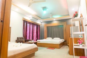 a hotel room with two beds and a chair at Impulse Ocean View in Cox's Bazar