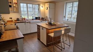 3 Bedroom Country Family Home near Masham في ماشام: مطبخ بخزائن بيضاء وطاولة خشبية