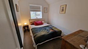 3 Bedroom Country Family Home near Masham في ماشام: غرفة نوم صغيرة بها سرير ونافذة
