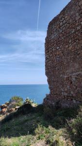 a stone wall with the ocean in the background at Rais Gerbi Appartamento in Pollina