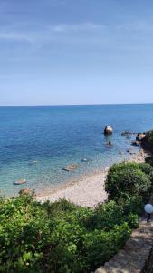 a beach with a rock in the water at Rais Gerbi Appartamento in Pollina
