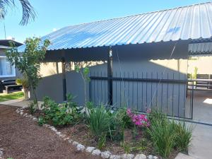 a house with a metal roof and some flowers at Urban Farm Haus Homestead in Rundu