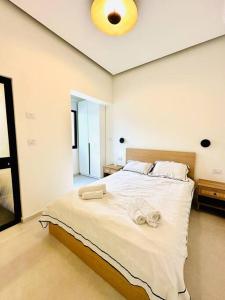 a bedroom with a large bed with towels on it at A luxury apartment in the Neve Tzedek neighborhood in Tel Aviv