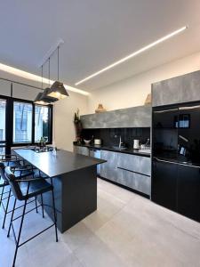 a large kitchen with a counter and chairs in it at A luxury apartment in the Neve Tzedek neighborhood in Tel Aviv