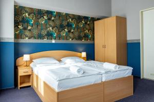 a bedroom with a bed with white sheets and pillows at Gartner Hotel in Budapest