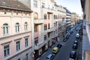 una calle de la ciudad con coches estacionados en los lados de los edificios en Gartner Hotel en Budapest