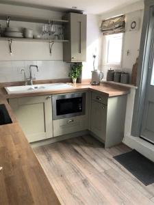a kitchen with a sink and a microwave at Stylish Town House in Medieval Grid in Bury Saint Edmunds