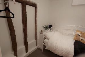 - une chambre avec un lit blanc et des poutres en bois dans l'établissement Stylish Town House in Medieval Grid, à Bury St Edmunds