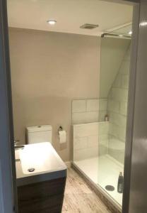 La salle de bains est pourvue d'une douche et d'un lavabo blanc. dans l'établissement Stylish Town House in Medieval Grid, à Bury St Edmunds