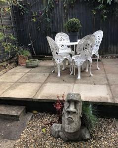 a garden with chairs and a statue of a head at Stylish Town House in Medieval Grid in Bury Saint Edmunds