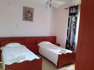 sypialnia z 2 łóżkami i lustrem w obiekcie Kanushi house w Gjirokastrze