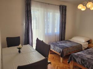 um quarto com duas camas e uma mesa e cadeiras em Roko em Trogir