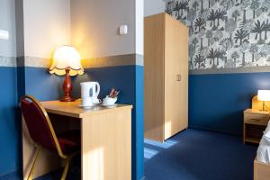 Zimmer mit Schreibtisch und Lampe in der Unterkunft Gartner Hotel in Budapest