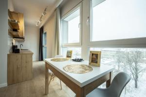 a kitchen with a table and chairs and a window at WiguryTower Apartaments 63' in Łódź