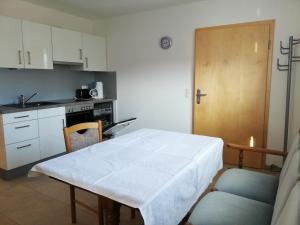 une cuisine avec une table et un chiffon de table blanc dans l'établissement Ferienwohnungen Weishaupt Pfingstweider Straße 30, à Meckenbeuren 7 autres photos