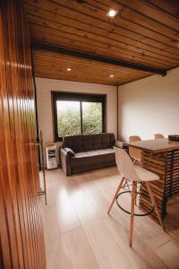 Pousada Colina Verde في غاروبابا: غرفة معيشة مع أريكة وطاولة وكراسي