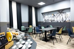 a dining room with tables and chairs and windows at Gartner Hotel in Budapest