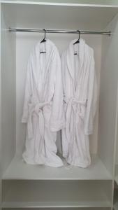 two white robes hanging on a rack in a closet at HIGHVILL PARK in Taldykolʼ