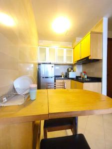 a kitchen with a wooden table and yellow cabinets at [HERITAGE 4] HOMESTAY Studio 4Pax, FREE WIFI in Seri Kembangan