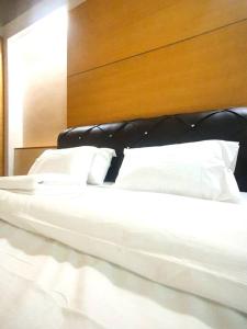 a white bed with a black headboard and white pillows at [HERITAGE 4] HOMESTAY Studio 4Pax, FREE WIFI in Seri Kembangan