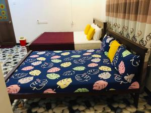 a bedroom with two beds and a bedspread with cats on it at Vihanga Guest House in Habarana