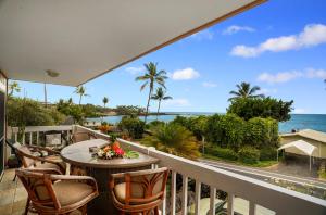balcón con mesa, sillas y vistas al océano en Kahaluu Reef 203, en Kailua-Kona