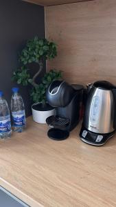 a coffee maker sitting on a counter with a plant at AA Apartment in Ventspils