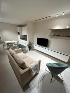 a living room with a couch and a flat screen tv at Lido Mare by Massi in Lido di Camaiore