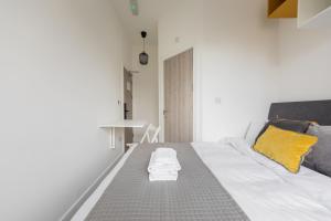 a living room with a white couch and yellow pillows at Cozy Ensuite Bedroom for Two near Tufnell Park in London