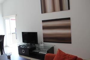 a living room with a flat screen tv on a wall at Limnaria Westpark in Paphos