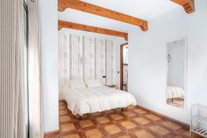 een slaapkamer met een bed en een spiegel bij Apartamentos La Solana de Monfragüe in Malpartida de Plasencia