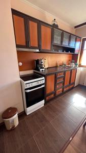 a kitchen with wooden cabinets and a stove top oven at Valevitsata Guesthouse in Razlog