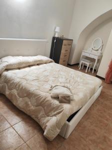 un grande letto in una camera da letto con cassettiera di Casa Coccinella a Nocera Umbra