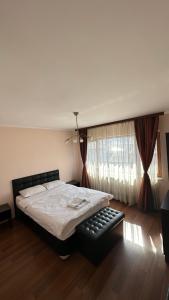 ein Schlafzimmer mit einem Bett und einem großen Fenster in der Unterkunft Valevitsata Guesthouse in Raslog
