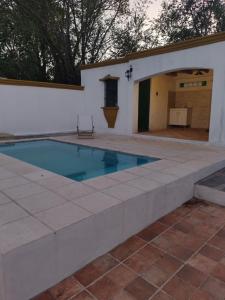 una piscina en un patio trasero con una pared blanca en La Casona de Cerro Colonial, en Trapiche