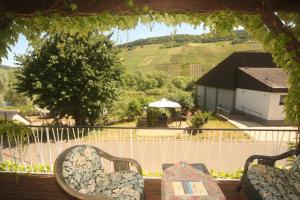 a porch with two chairs and a view of a house at Ferienwohnung „Schwalbennest“ Reil/Mosel in Reil