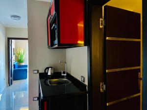uma cozinha com um lavatório e um armário vermelho em Porto marina chalet and apartment em El Alamein