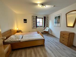 1 dormitorio con cama, tocador y espejo en Fewo Susi Allgäu, en Buchloe