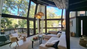 a living room with a couch and a large window at Haus del Arroyo - Andarlibre in San Martín de los Andes