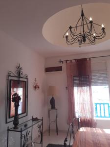 a bedroom with a chandelier and a mirror and a bed at Résidence meriem 2 in Hammamet
