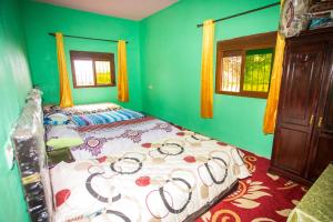 a bedroom with a bed in a room with green walls at La belle vue in Daher