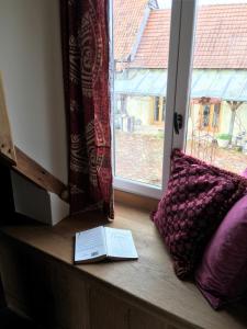 un libro sentado en un alféizar junto a una almohada en Farmhouse Gite, en Saint-Georges