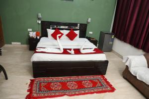 um quarto com uma cama com almofadas vermelhas e brancas em Ashray House Noida em Noida