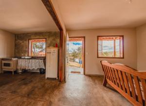 an empty living room with a refrigerator and a table at Vila Espinhaço in Diamantina