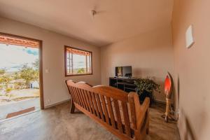 a room with a bench and a tv and a window at Vila Espinhaço in Diamantina