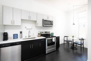 a kitchen with white cabinets and a table with chairs at Flexhome Skywalk to Fiserv 1BR Apt U6 - READ INFO in Milwaukee